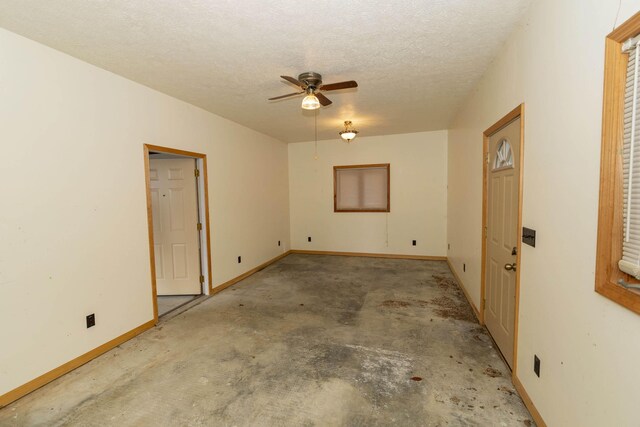 21734 N Channel Pkwy, Edwardsburg, MI 49112 - spare room with ceiling fan, unfinished concrete floors, a textured ceiling, and baseboards