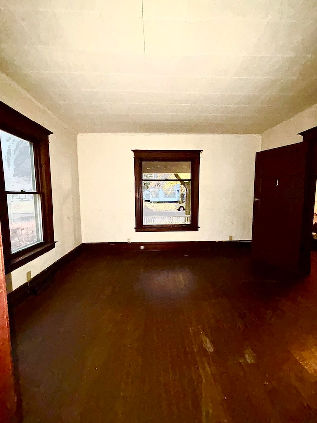 empty room with hardwood / wood-style floors and a healthy amount of sunlight