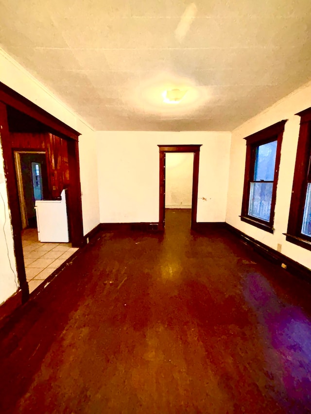 empty room with washer / dryer and hardwood / wood-style flooring