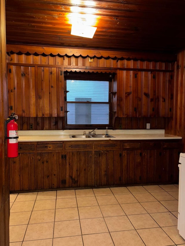 kitchen with dark brown cabinets, wooden ceiling, sink, and light tile patterned floors