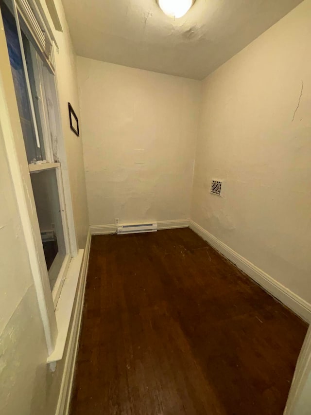 clothes washing area with hardwood / wood-style flooring and a baseboard radiator