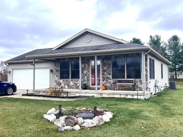 view of front facade with cooling unit, a front yard, and a garage