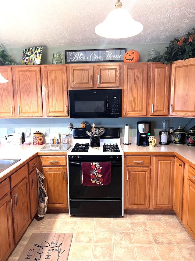 kitchen with black appliances, light tile patterned floors, and a textured ceiling