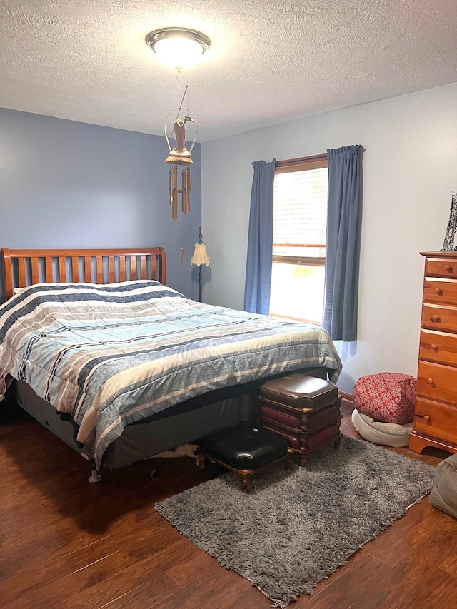 bedroom featuring dark hardwood / wood-style flooring and a textured ceiling