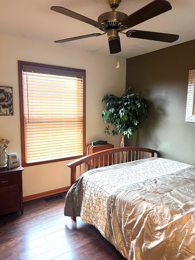 bedroom with dark hardwood / wood-style flooring and ceiling fan