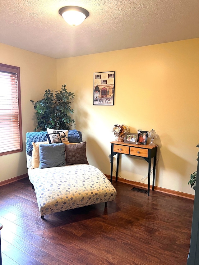 sitting room with dark hardwood / wood-style flooring and a textured ceiling