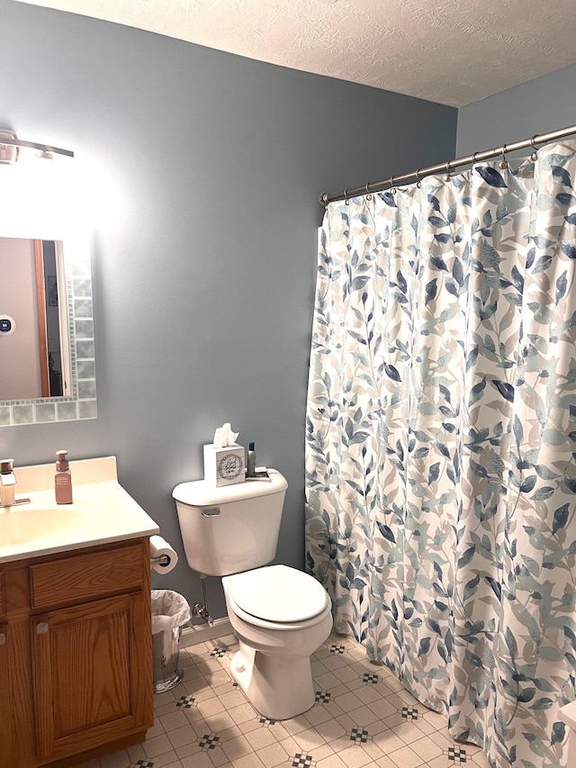 bathroom featuring tile patterned flooring, vanity, and a textured ceiling