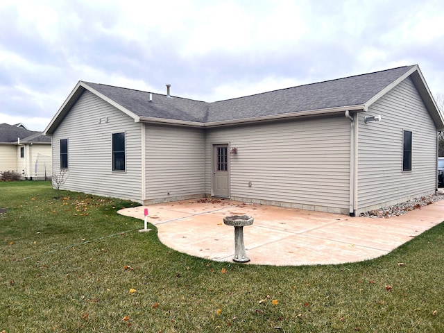 rear view of property featuring a patio and a yard