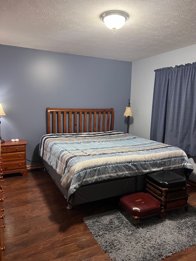 bedroom with dark hardwood / wood-style flooring and a textured ceiling