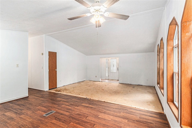 empty room featuring a textured ceiling, ceiling fan, dark wood-type flooring, and vaulted ceiling