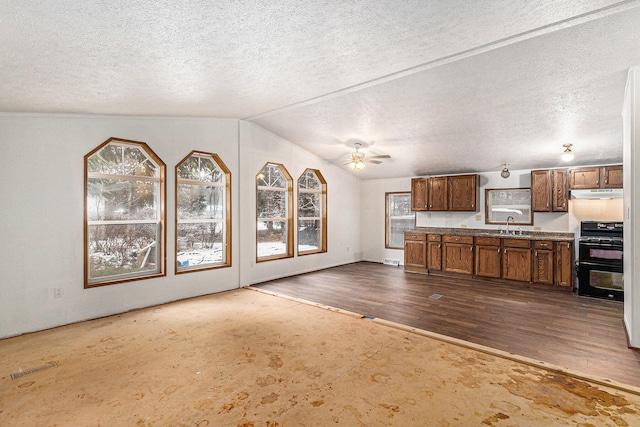 unfurnished living room featuring dark hardwood / wood-style floors, ceiling fan, lofted ceiling, and a textured ceiling