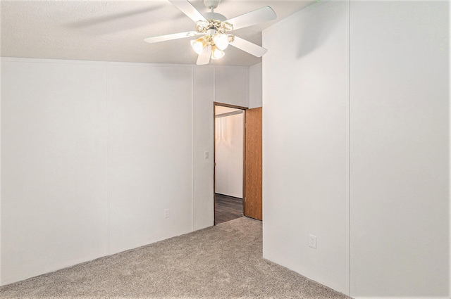 empty room featuring a textured ceiling, ceiling fan, carpet, and lofted ceiling