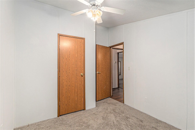 unfurnished bedroom with carpet flooring, a textured ceiling, and ceiling fan