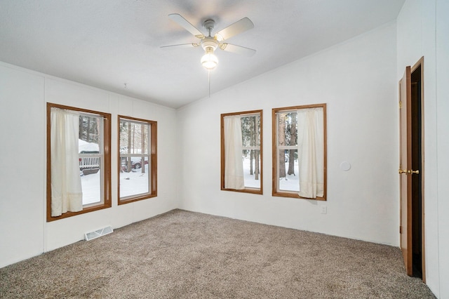 carpeted spare room featuring ceiling fan and vaulted ceiling