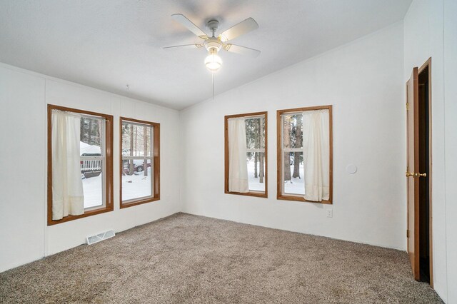 carpeted spare room with ceiling fan and vaulted ceiling