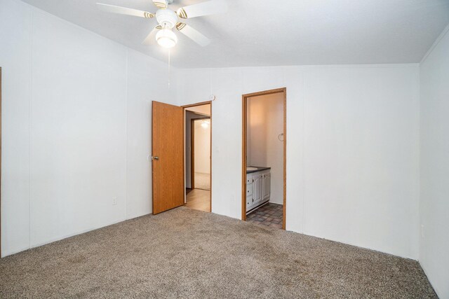 unfurnished bedroom with ceiling fan, ensuite bath, vaulted ceiling, and light carpet