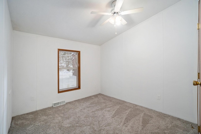 spare room featuring carpet, ceiling fan, and vaulted ceiling