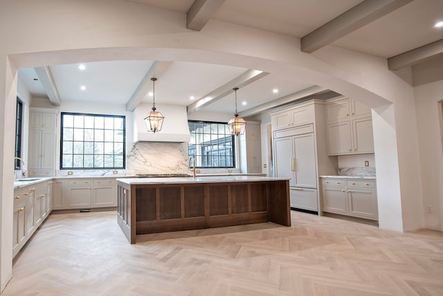 kitchen featuring a center island, paneled refrigerator, pendant lighting, and decorative backsplash