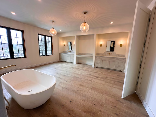 bathroom with vanity, hardwood / wood-style floors, and a tub