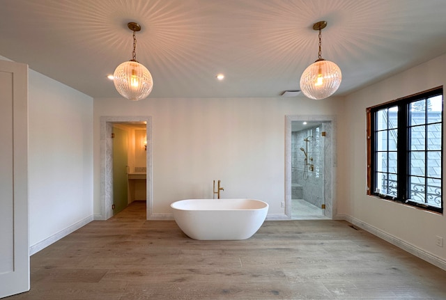 bathroom featuring hardwood / wood-style flooring and independent shower and bath