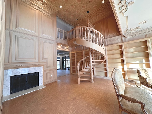 interior space featuring parquet floors, a towering ceiling, a premium fireplace, and built in features