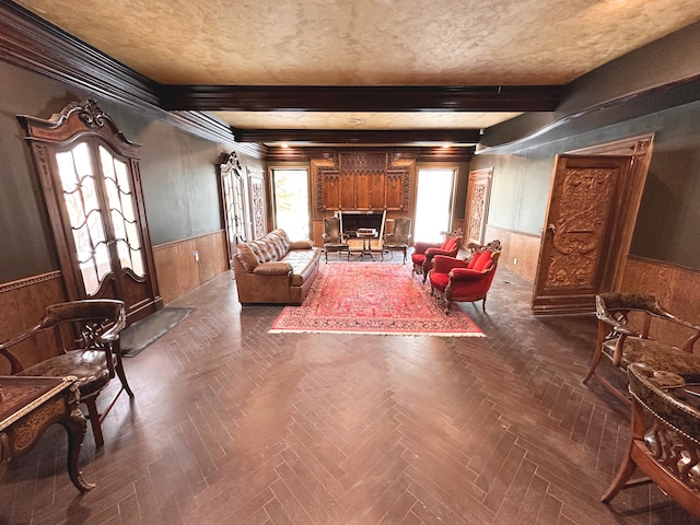 interior space with a textured ceiling, dark parquet floors, beamed ceiling, and wood walls