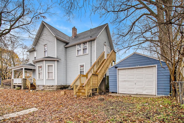 back of house with a garage and an outdoor structure