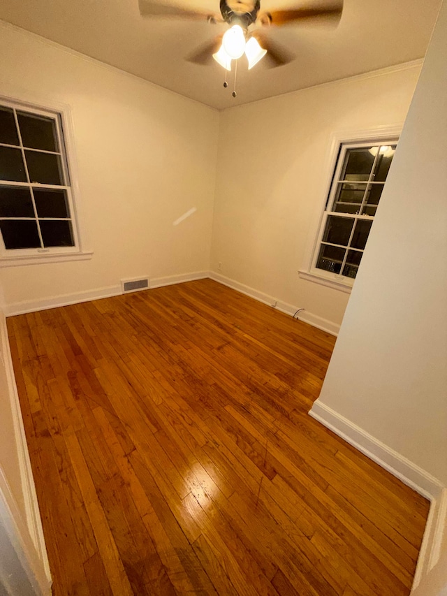 empty room with hardwood / wood-style flooring and ceiling fan