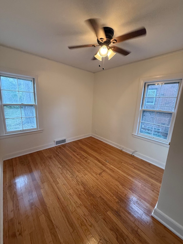 spare room with ceiling fan, light wood-type flooring, and a textured ceiling