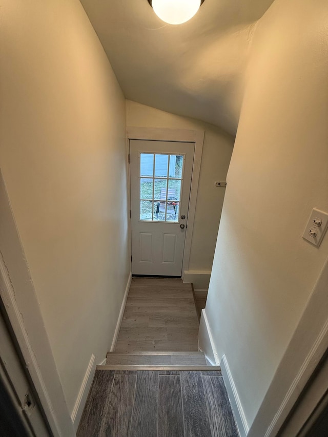 doorway to outside with dark wood-type flooring and vaulted ceiling