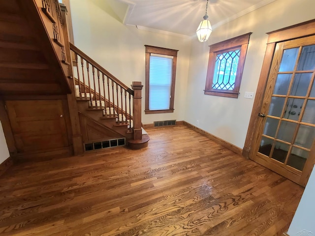 foyer entrance featuring crown molding and hardwood / wood-style floors