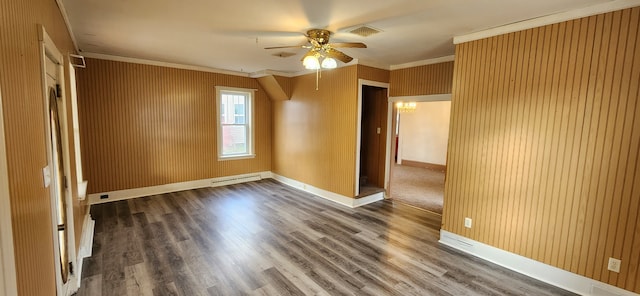 spare room with ceiling fan, wood-type flooring, crown molding, and wooden walls