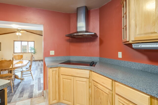 18980 16 Mile Rd, Marshall, MI 49068 - kitchen with wall chimney exhaust hood, black electric stovetop, light brown cabinetry, ceiling fan, and lofted ceiling