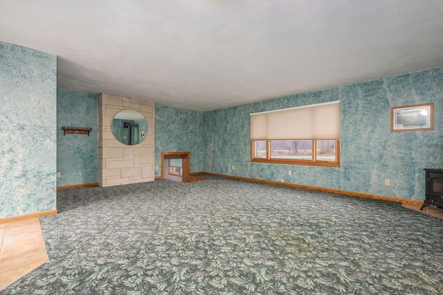 18980 16 Mile Rd, Marshall, MI 49068 - unfurnished living room featuring a wood stove, baseboards, and carpet floors