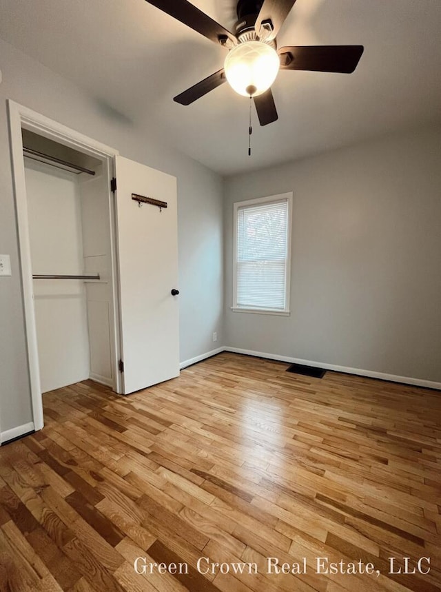 unfurnished bedroom featuring ceiling fan, light hardwood / wood-style flooring, and a closet