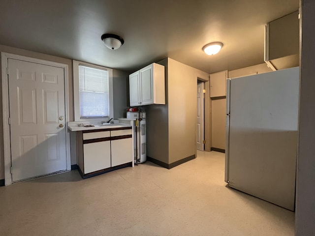 25846 W 7 Mile Rd, Redford, MI 48240 - kitchen featuring freestanding refrigerator, white cabinetry, a sink, light countertops, and baseboards