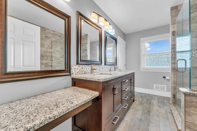 bathroom with hardwood / wood-style flooring, vanity, and a shower with shower door