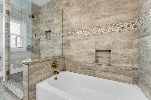 bathroom featuring shower with separate bathtub