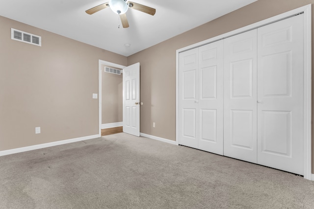 unfurnished bedroom featuring a closet, ceiling fan, and light colored carpet