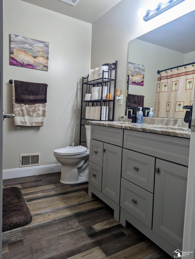 bathroom with vanity, toilet, and wood-type flooring