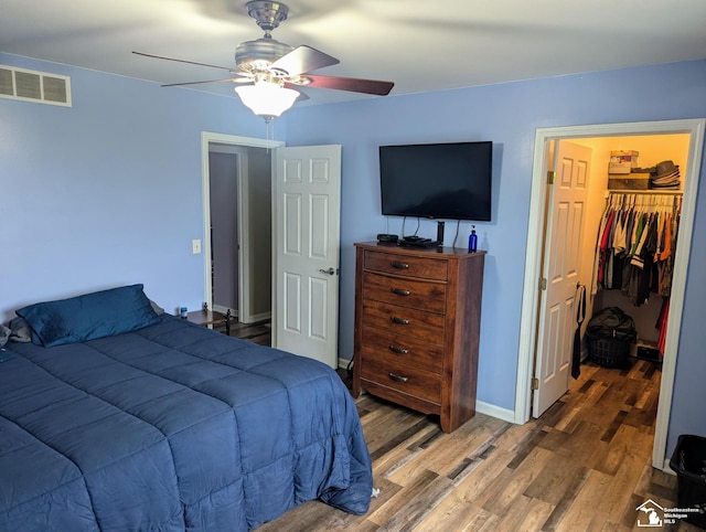 bedroom featuring wood-type flooring, a closet, a spacious closet, and ceiling fan