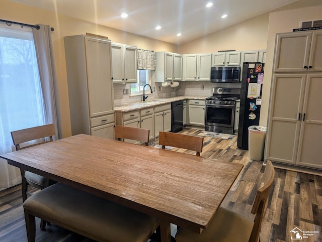 kitchen with sink, dark wood-type flooring, tasteful backsplash, lofted ceiling, and black appliances