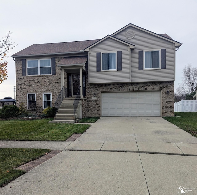 split foyer home featuring a garage and a front yard