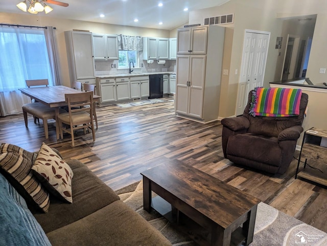 living room featuring dark hardwood / wood-style flooring, lofted ceiling, and sink