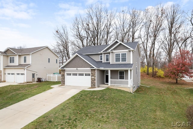 view of front of property with covered porch, a garage, and a front yard