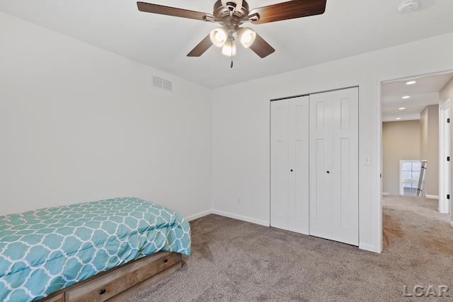 carpeted bedroom with ceiling fan and a closet