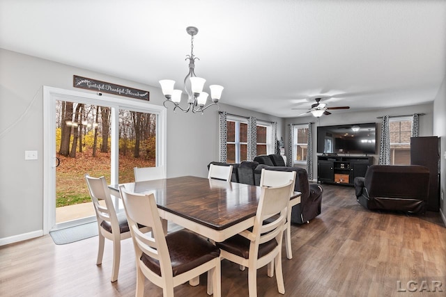 dining area featuring hardwood / wood-style floors and ceiling fan with notable chandelier