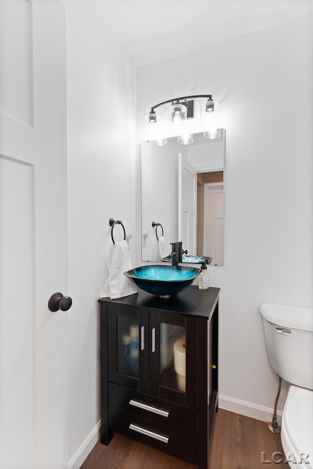 bathroom featuring vanity, toilet, and wood-type flooring