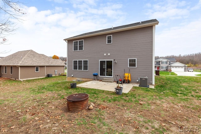 rear view of property featuring a lawn, a patio area, and central air condition unit