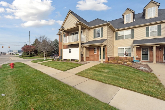 view of front of house with a balcony and a front lawn